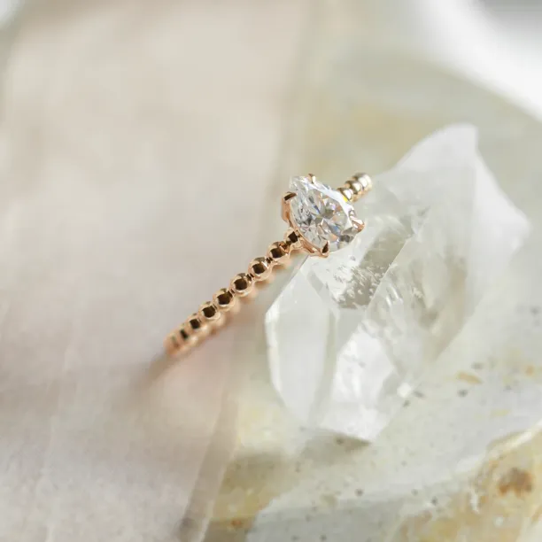 Gold engagement ring with beaded ball setting and pear moissanite BEAU Image