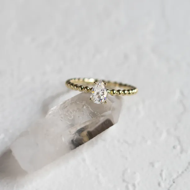 Gold engagement ring with beaded ball setting and pear moissanite BEAU Image