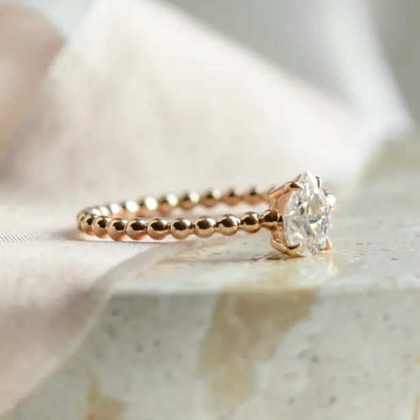 Gold engagement ring with beaded ball setting and pear moissanite BEAU Image