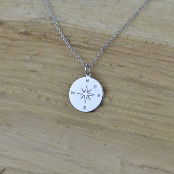 Gold pendant with a compass and a diamond MAP Image