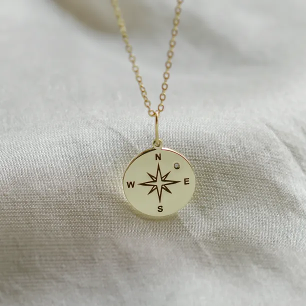 Gold pendant with a compass and a diamond MAP Image