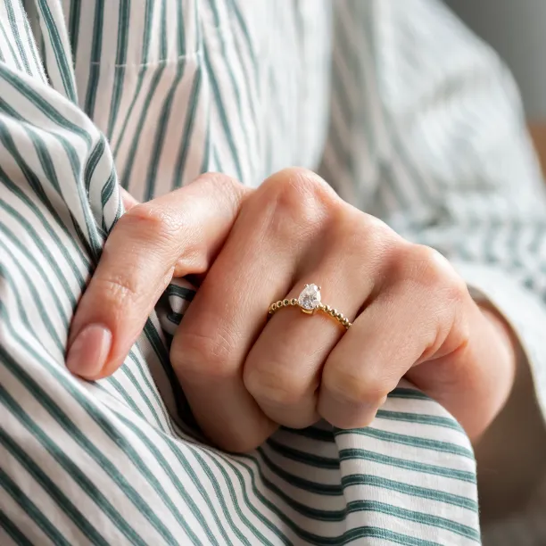 Gold engagement ring with beaded ball setting and pear moissanite BEAU Image