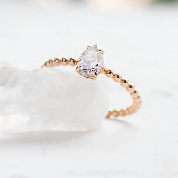 Gold engagement ring with beaded ball setting and pear moissanite BEAU Image