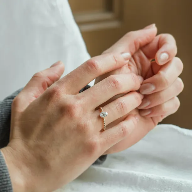 Gold engagement ring with beaded ball setting and pear moissanite BEAU Image