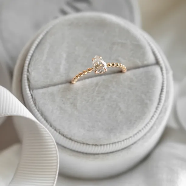 Gold engagement ring with beaded ball setting and pear moissanite BEAU Image