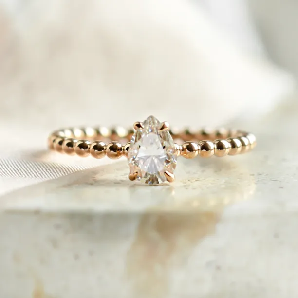 Gold engagement ring with beaded ball setting and pear moissanite BEAU Image
