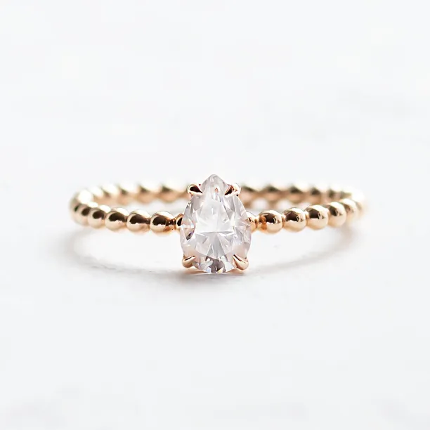 Gold engagement ring with beaded ball setting and pear moissanite BEAU Image