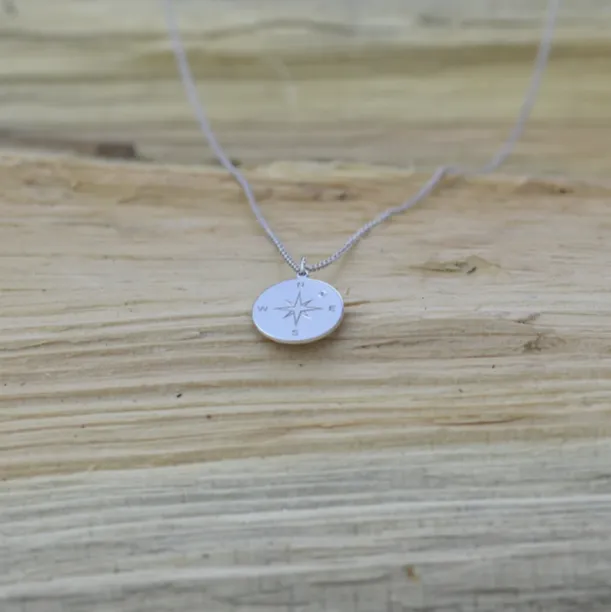 Silver pendant with a compass and a diamond MAP Image